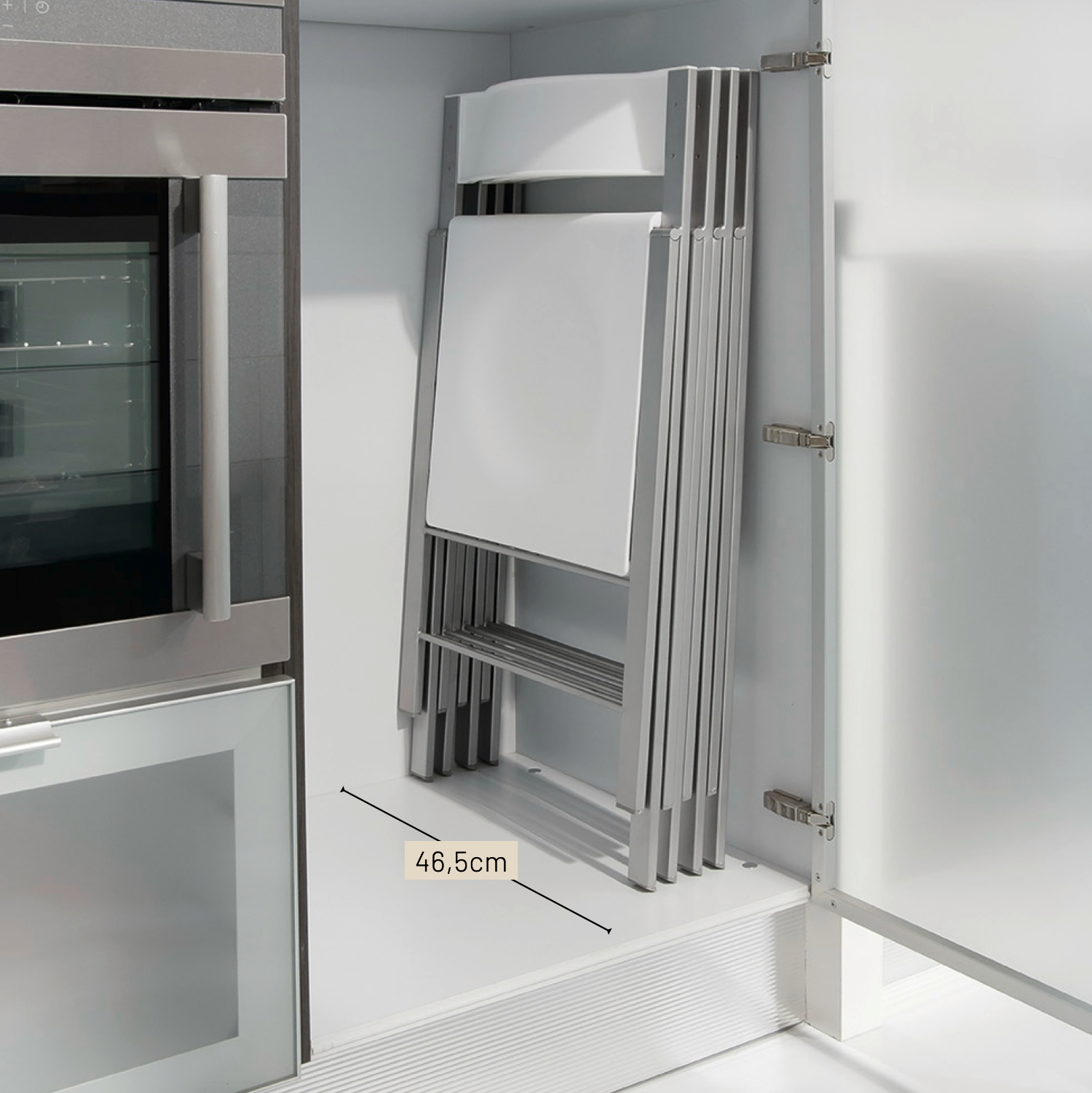 4 sillas plegadas guardas en un mueble bajo de cocina.